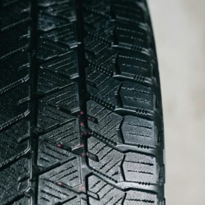Detailed close-up of a car tire tread showcasing intricate rubber patterns, ideal for automotive themes.